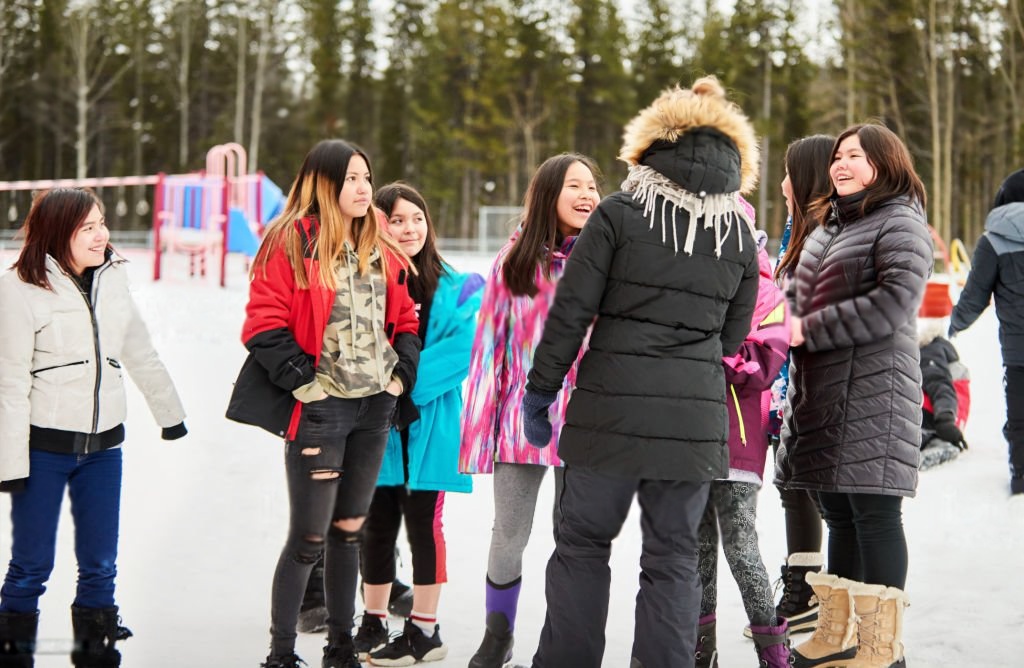 Group of Indigenous teenage girls hugging and smiling