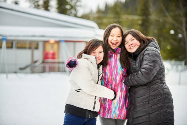 Group of Indigenous teenage girls hugging and smiling